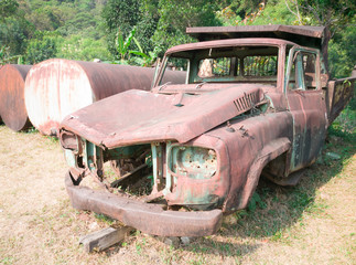 Old rusted car in junk yard .