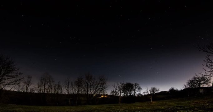 Night stars flowing above countryside. Time Lapse.