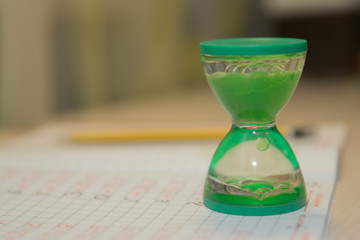 hourglass stand on a notebook in mathematics