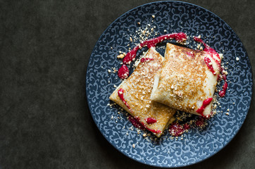 Pancakes with custard and cherry strawberry coulis and nuts