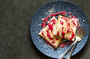 Pancakes with custard and cherry strawberry coulis and nuts