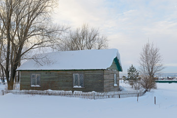 old wooden house in a snowy field