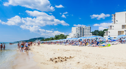 The Black Sea shore, blue clear water, beach with sand, umbrellas and sunbeds. Albena, Bulgaria