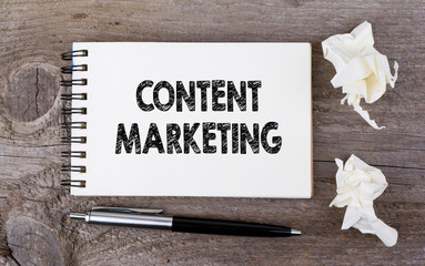 Content Marketing. On a wooden table notebook and pen.