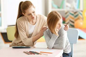 Young female psychologist working with teenager girl in office
