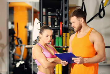 Young woman with personal trainer in gym