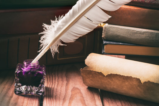 Literature concept. Old inkstand with feather near scroll and books