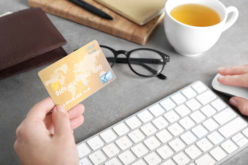 Woman holding credit card and using computer