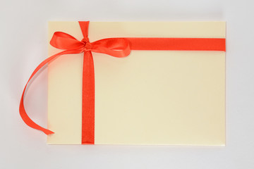 Light yellow envelope with a red ribbon on a white background