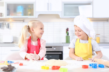Little kids making biscuits on table