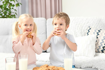 Little kids eating cookies at home