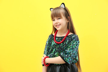 Cute little girl on yellow background