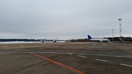 Aircraft parking in the passenger airport on a cloudy winter day
