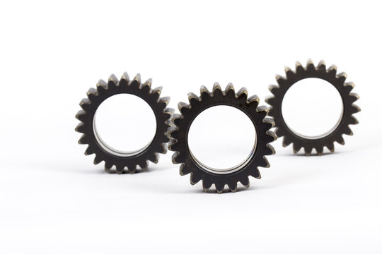 Small group of gears with their teeth engaged on a white background.