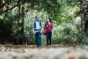 Naklejka na ściany i meble Traveler couple with backpack mountaineering Travel Lifestyle concept forest on background