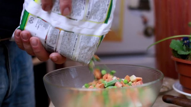 Frozen vegetables dropping into bowl
