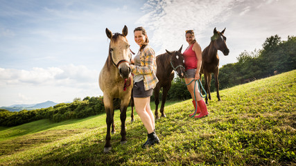 Two girls with a horse on a field in Slovakia