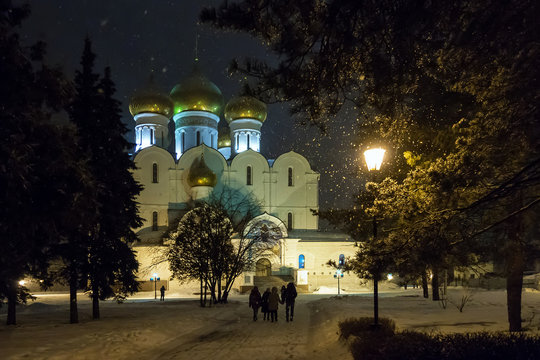 Assumption Cathedral in Yaroslavl. Russia. People walk in the evening in the park near the Orthodox sobora.Idet snow, shine lights.