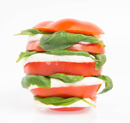 Caprese salad - tomato with mozzarella and basil on a white background