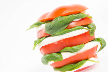 Caprese salad - tomato with mozzarella and basil on a white background