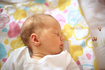 newborn baby sleeping in the crib on a blanket
