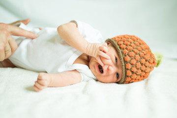 cute newborn baby in knitted hat lying