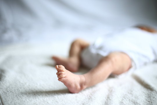 foot of a newborn who is sleeping peacefully in the crib