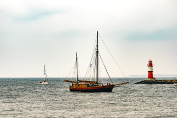 Fototapeta premium Sailing ship on the sea. Tall Ship and lighthouse Yachting travel.