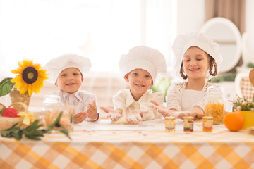 happy little children in the form of a chef to cook a delicious breakfast in the kitchen