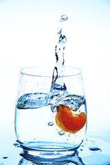 water splash in glass from falling slices of mandarin