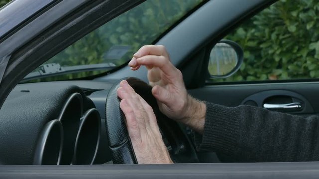 Nervous driver, closeup of hands at wheel tapping and gesturing 