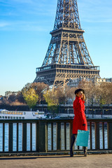 happy trendy woman standing on embankment in Paris, France