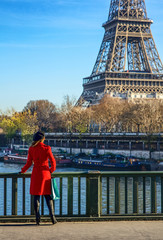 woman standing on embankment near Eiffel tower in Paris, France