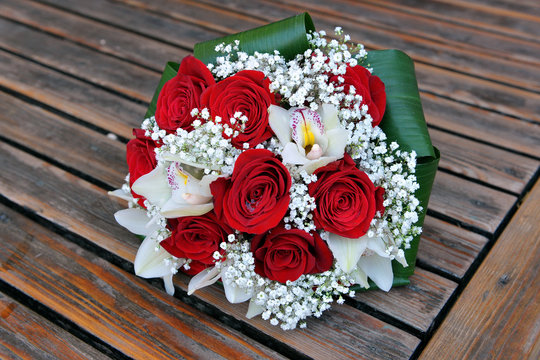 Bouquet of roses and orchids. Flowers on wood
