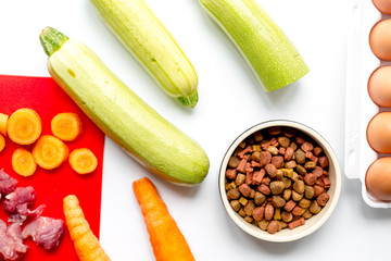healthy dogfood with eggs, vegetables and meat on kitchen background top view