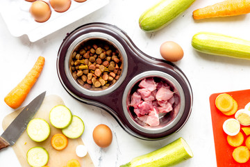 petfood set with vegetables and meat on kitchen table background top view