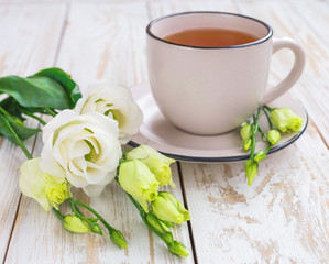 Cup of hot tea and white eustoma flowers