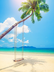Beautiful tropical island beach with coconut palm trees and swing