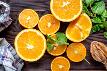 orange juice with mint squeezing on wooden kitchen background top view