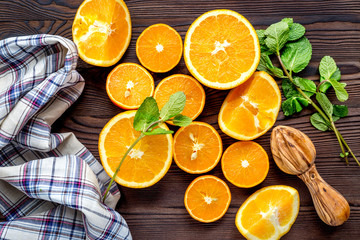 Fresh oranges in slices with mint leaves on kitchen top view