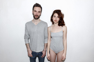 Young and carefree. Beautiful couple by the grey wall