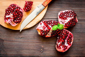 sliced pomegranate on wooden background top view