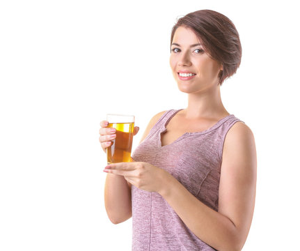 Young beautiful woman with glass of apple juice, on light background