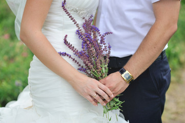 Fototapeta premium Bride with groom and bouquet of field flowers