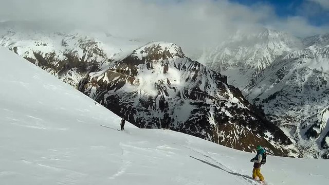 freeriding in the mountains. Skier and snowboarder riding.