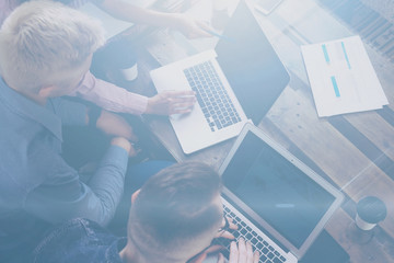 Top view of young team of coworkers making great work discussion in modern office.Man discussing with colleagues stratup project.Business people meeting concept.Horizontal, blurred background.