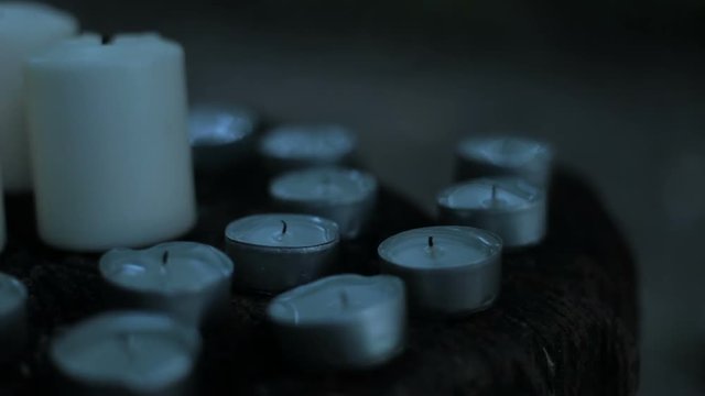 Tea light candles being blown out in the dark forest at night