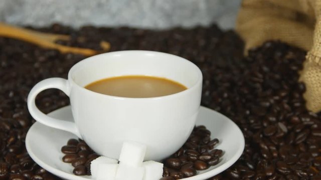 panning shot of coffee cup on coffee beans background