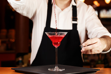 Barman in making cocktail at a nightclub. Nightlife concept. No face. Pouring into glass