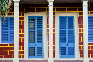 Two tropical bright blue doors and brick design building exterior